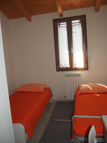 佩萨罗Agriturismo Ardizio 43的一间卧室设有两张床和窗户。