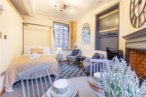 赫里福德Guest Homes - The Merchant House Apartments的酒店客房配有一张床和一个壁炉。