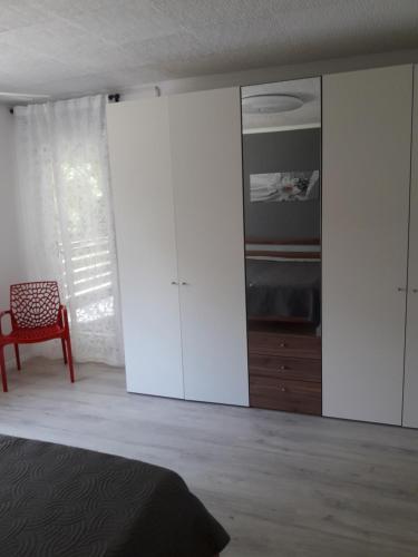 阿伦Ferienwohnung an der Klinge的卧室配有白色橱柜、一张床和一把椅子