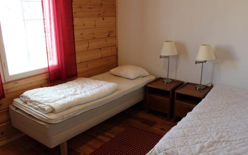 耶姆赛Himoseasy Cottages的一间小卧室,配有两张床和两盏灯