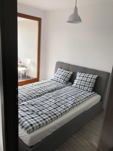 绿山城Apartament Ptasia的卧室内的一张带 ⁇ 面床单和镜子的床
