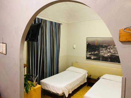 都灵Hotel Ferrucci的一间设有两张床和一个拱形门廊的房间
