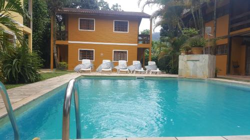 博西坎加Vila da Praia的一个带椅子的游泳池以及一座房子