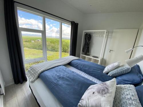 海拉Skeiðvellir Panorama house的一间卧室设有一张床和一个大窗户
