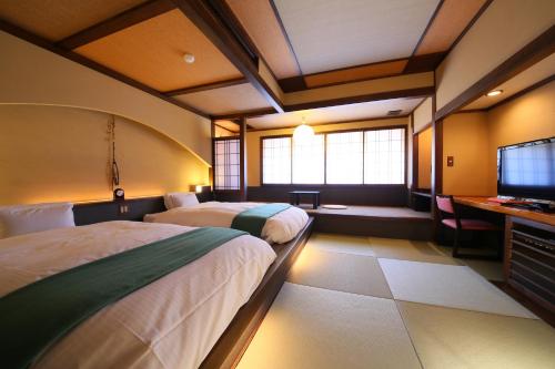 松本玉之汤酒店的酒店客房设有两张床和电视。