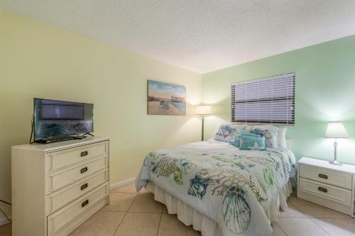 圣徒皮特海滩407 Beach Place Condos的一间卧室配有一张床和一台平面电视
