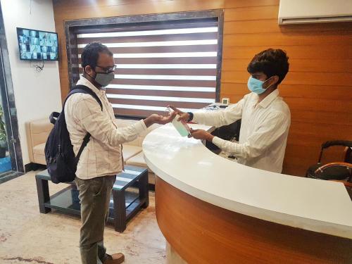 新德里Hotel Delhi Aerocity, NH 8的两个人戴面具站在柜台