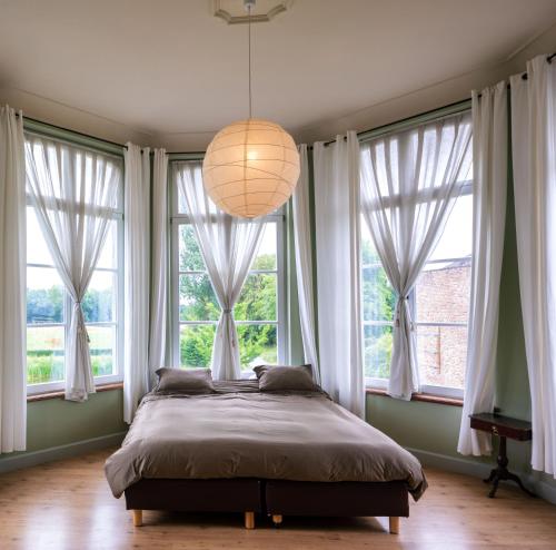 圣特雷登Kasteel Nieuwenhoven的卧室的窗户前设有一张大床