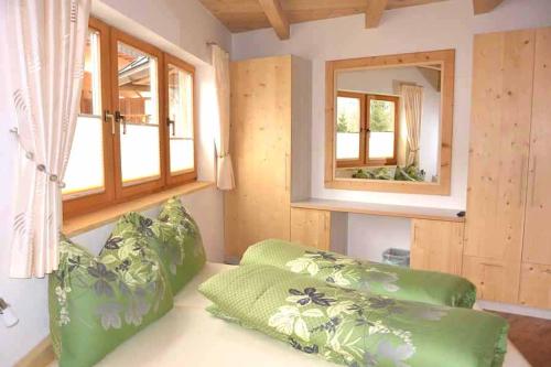 伊特尔Ferienhaus Oktogon的一间设有两张绿色椅子和镜子的房间