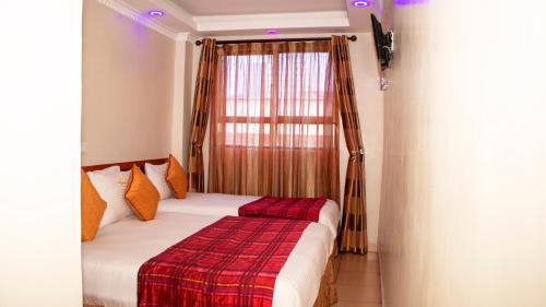 内罗毕Sheratton Regency Hotel Nairobi的一间卧室配有一张带红白毯子的床
