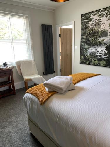 米尔福德昂西THE LAZY LION的一间卧室配有一张床、一把椅子和窗户。