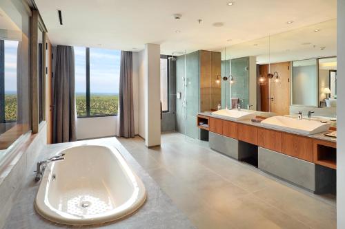 外南梦Kokoon Hotel Banyuwangi的大型浴室设有两个盥洗盆和一个大浴缸。