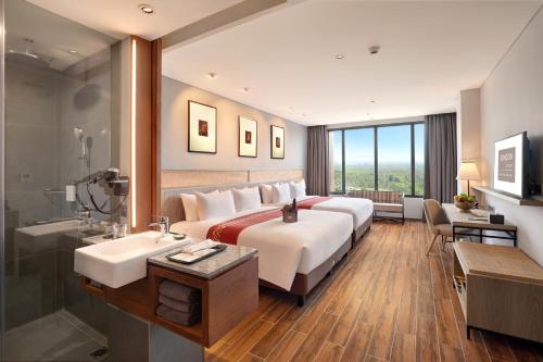 外南梦Kokoon Hotel Banyuwangi的酒店客房设有一张大床和一个水槽