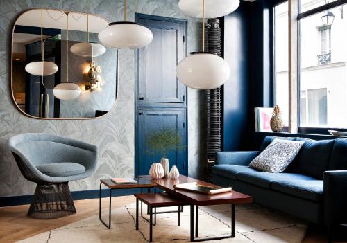 巴黎亨丽埃特酒店的客厅配有蓝色的沙发和蓝色的椅子