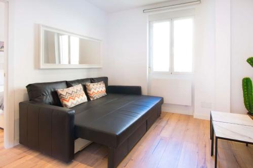 马德里1 bedroom 1 bathroom furnished - Salamanca - executive style - MintyStay的客厅里一张黑色皮沙发