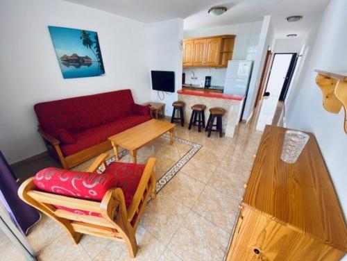 英格兰海滩桑德拉公寓的客厅配有红色的沙发和桌子