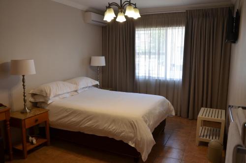 布隆方丹Hydro Guesthouse的一间卧室设有一张大床和一个窗户。