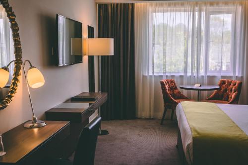 卡文克洛莫尔酒店的配有一张床、一张桌子和一张桌子的酒店客房