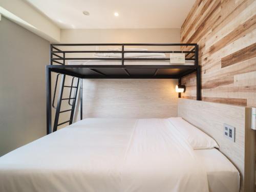 东京横丁品川青物超级酒店的一间卧室配有一张双层床和木墙
