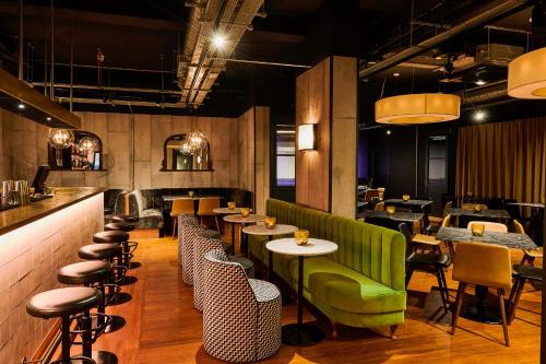 伦敦富勒张伯伦酒店的餐厅设有绿色的沙发和桌椅
