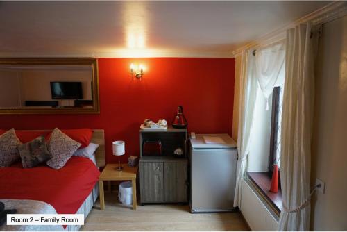 阿伯克拉夫彭特利马术酒店的卧室设有红色的墙壁、一张床和一张桌子