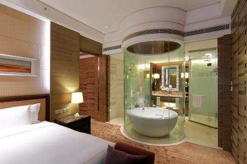 南京Crowne Plaza Nanjing Jiangning, an IHG Hotel的一间带一张床的卧室和一间带浴缸的浴室