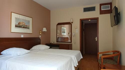 雅典经济酒店的酒店客房,配有床和镜子