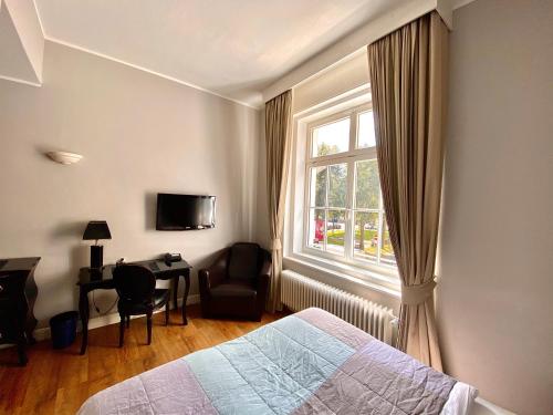 慕尼黑大肆尼古拉酒店的一间卧室配有一张床、一个窗口和一张书桌