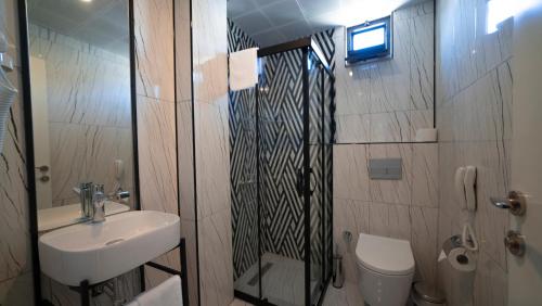 安塔利亚The Mori Club Hotel的带淋浴、盥洗盆和卫生间的浴室
