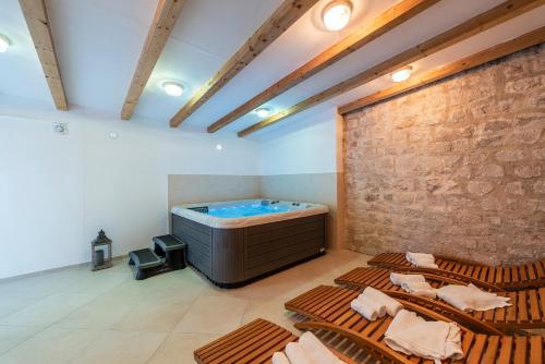帕科坦Heritage Hotel Maskovica Han的大型客房设有热水浴缸和椅子。