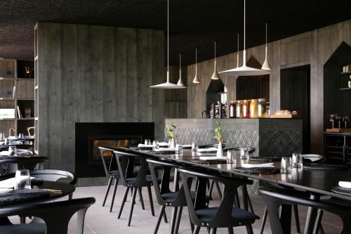 BreitenbachHôtel 48°Nord & Restaurant, The Originals Relais的一间带长桌和椅子的用餐室