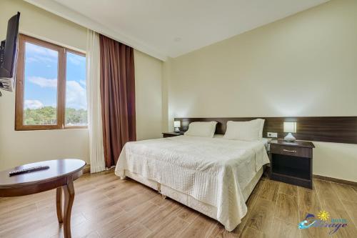 谢赫维蒂利Mirage Hotel的酒店客房设有床、桌子和窗户。