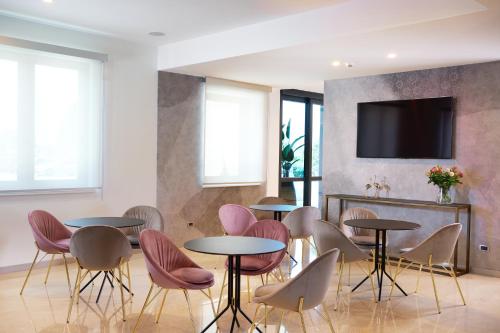 皮亚韦河畔诺文塔奥姆尼亚酒店的配有桌椅和电视的客房