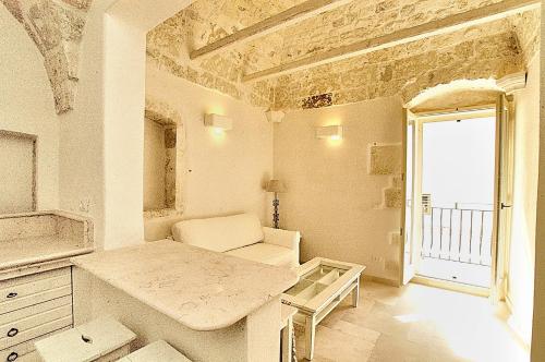 奥斯图尼Casa Antica Roma的白色的客房设有桌子和窗户。