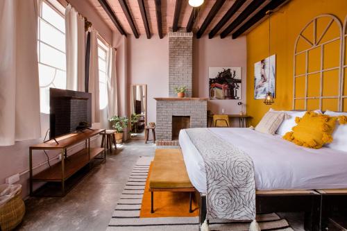 圣米格尔-德阿连德Selina San Miguel de Allende的一间卧室设有一张大床和一个壁炉