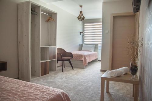 莱斯科瓦茨Mehana apartmani的一间卧室配有两张床、一张桌子和一把椅子