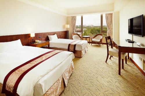 龙潭 渴望会馆 的酒店客房设有两张床、一张桌子和一台电视。