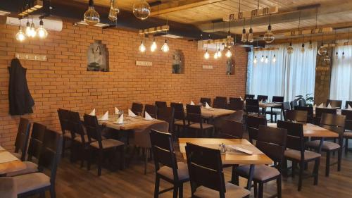 莱斯科瓦茨Mehana apartmani的餐厅设有木桌和椅子,拥有砖墙