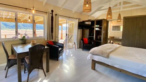 维德尼斯二人世界度假屋的卧室配有一张床和一张桌子及椅子