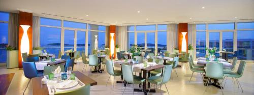 赫瓦尔安姆弗拉哈弗高级海滩度假酒店的用餐室设有桌椅和窗户。