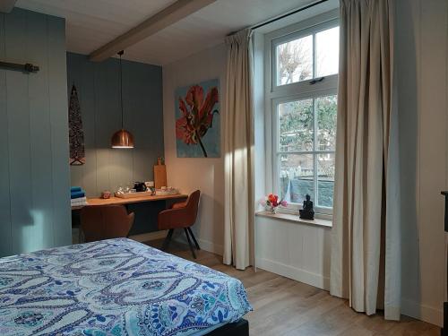 阿姆斯特丹B & B Tulp Amsterdam Noord的一间卧室配有一张床、一张书桌和一个窗户。