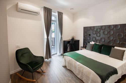 克里日亚Locanda Il Carugio的一间卧室配有一张床和一把绿色椅子