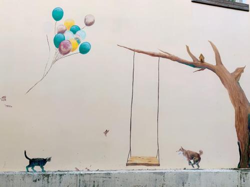 Xiluo西螺後街童话民宿的两只猫在墙上带着气球和一棵树行走