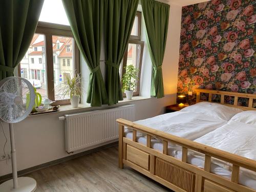 克滕Restaurant & Pension Stadtscheune的一间卧室设有床和配有绿色窗帘的窗户