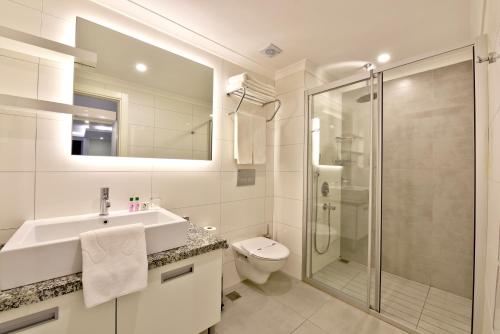 阿拉尼亚绿色花园套房酒店的浴室配有盥洗盆、卫生间和淋浴。