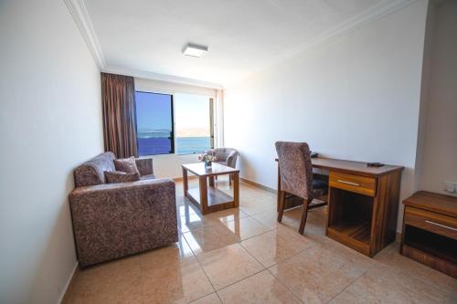 亚喀巴Joar Beach Hotel的客厅配有椅子、书桌和窗户