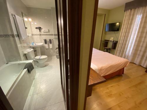 萨拉曼卡会议中心旅馆的客房设有带一张床和浴缸的浴室。