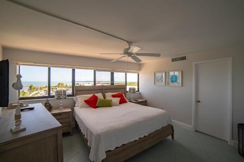 基拉戈Kawama Yacht Club Apartment的一间卧室配有一张带红色枕头的床和一扇窗户