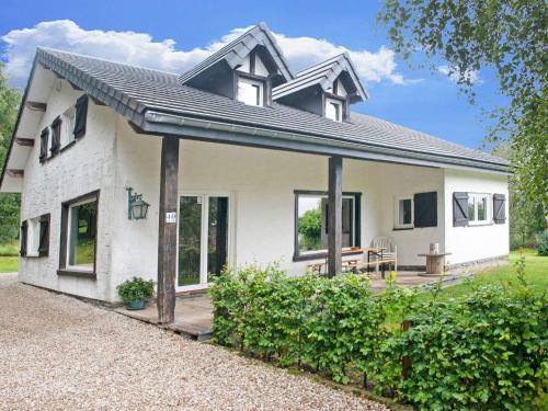 XhoffraixHoliday Home in Xhoffraix between Spa and Eifel Nature Park的白色的小房子,设有门廊和庭院