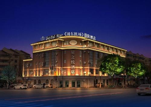上海星之悦酒店(免费提供浦东机场和迪士尼班车接送)的一座大建筑在晚上点燃